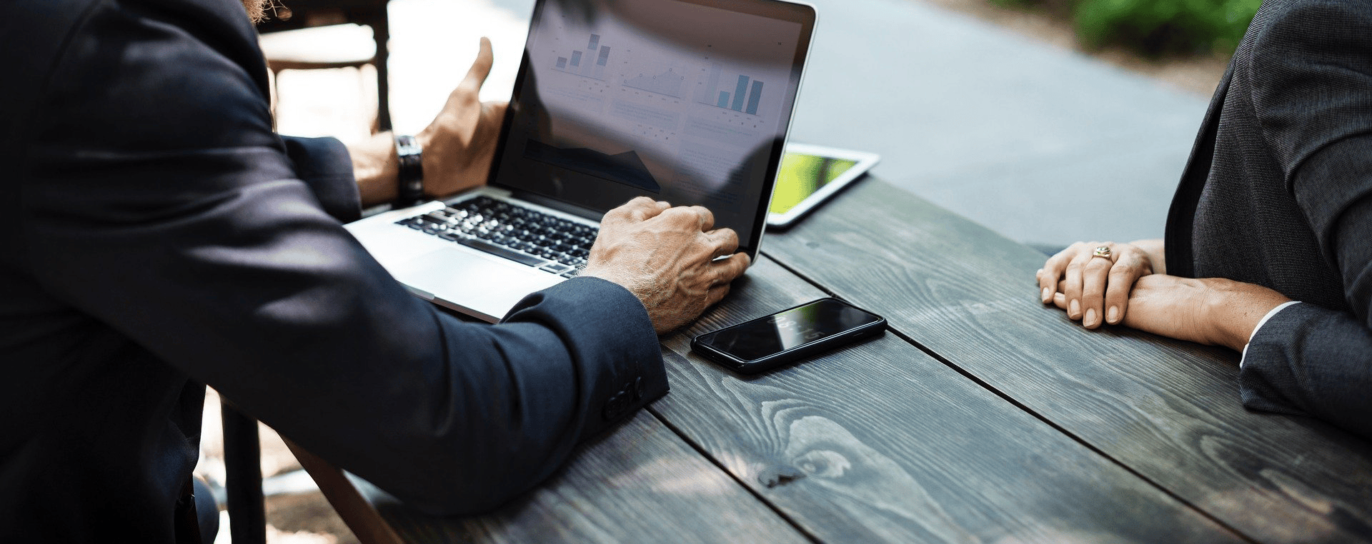 2 people sitting at an outside table